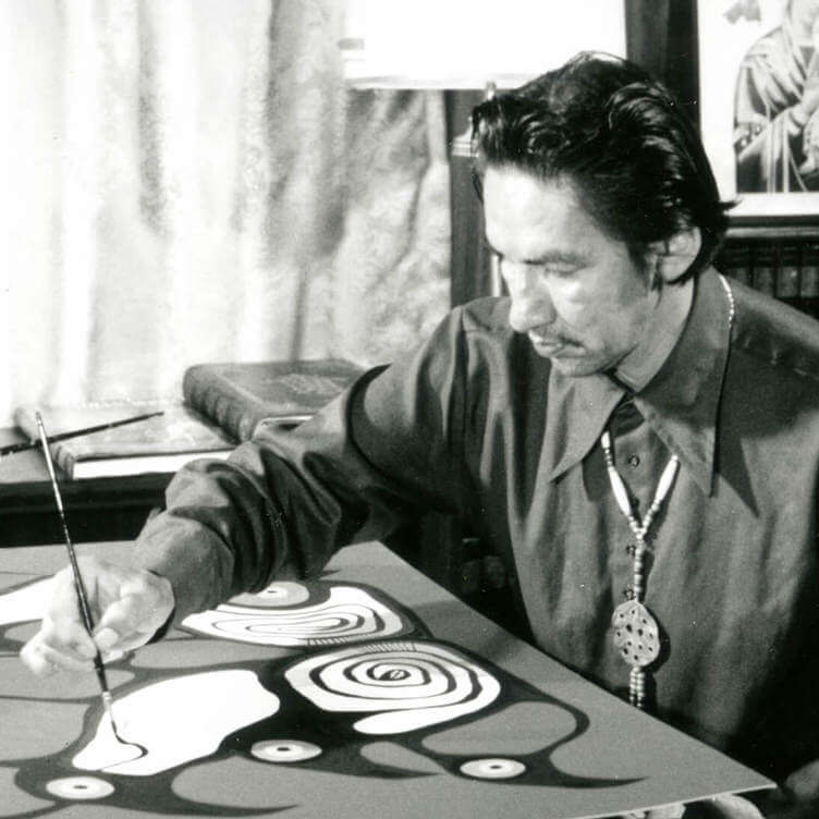 <p>Norval Morrisseau painting in his home in 1973 for the filming of the NFB documentary Paradox of Norval Morrisseau. Morrisseau did not have access to an artist-studio space.</p>
<p> </p>
<p>Banner: Norval Morrisseau, <em>Artist and Shaman between Two Worlds</em>, 1980, acrylic on canvas, 175 x 282 cm, National Gallery of Canada, Ottawa.</p>
