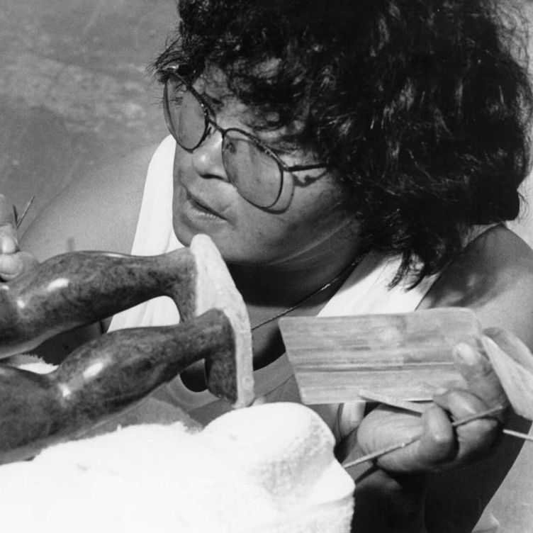 <p>Oviloo Tunnillie, 1992, photograph by John Graydon. </p>
<p> </p>
<p>Banner: Oviloo Tunnillie, <em>This Has Touched My Life</em>, 1991–92, serpentinite (Tatsiituq); woman, 16.7 x 9.5 x 7 cm; woman and child, 16.5 x 19.2 x 10.5 cm; man, 18.5 x 9 x 5.25 cm; car, 3 x 9.2 x 4.2 cm, signed with syllabics, Canadian Museum of History, Gatineau.</p>
