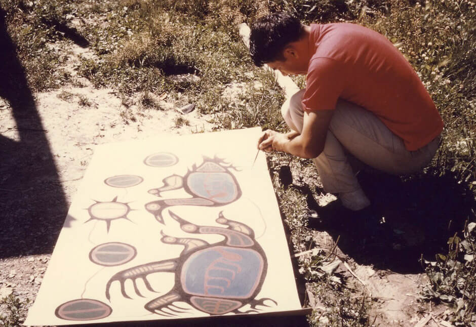 Art Canada Institute, Norval Morrisseau, Norval Morrisseau painting outdoors in Red Lake, August 1966