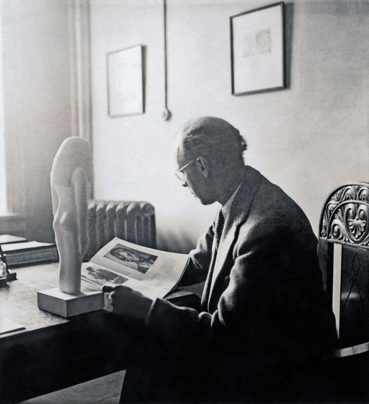 Art Canada Institute, photograph of Lionel LeMoine FitzGerald in his office, c. 1939, with a book open to a reproduction of Paul Cézanne’s Portrait of Victor Chocquet, 1877