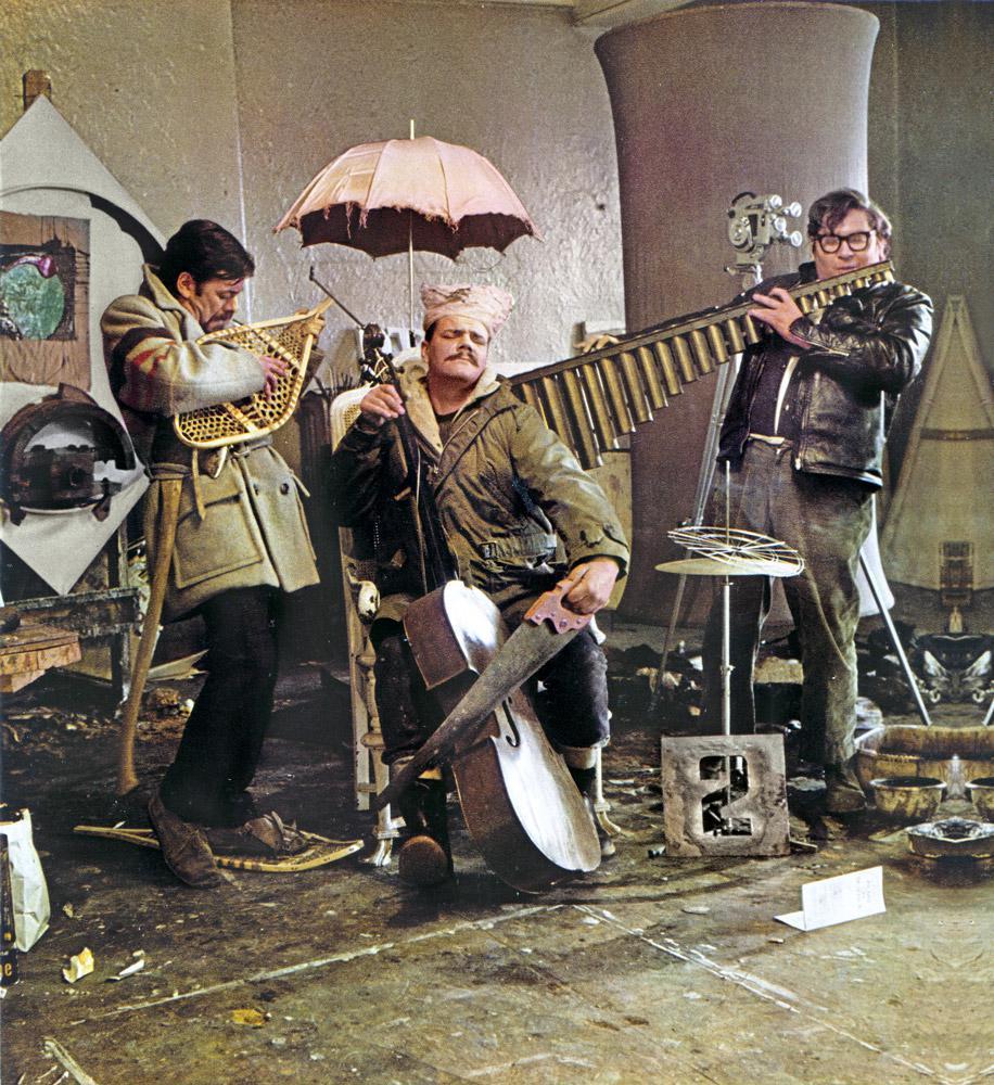 Art Canada Institute, photograph of Graham Coughtry, Gordon Rayner, and Robert Markle parody the Artists’ Jazz Band in Rayner’s Toronto studio, 1965