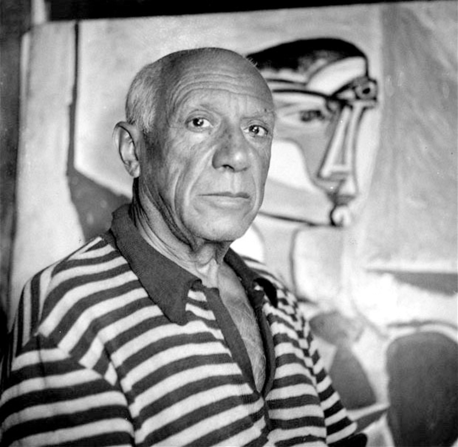 Pablo Picasso at home in Cannes, in front of one of his paintings, 1955