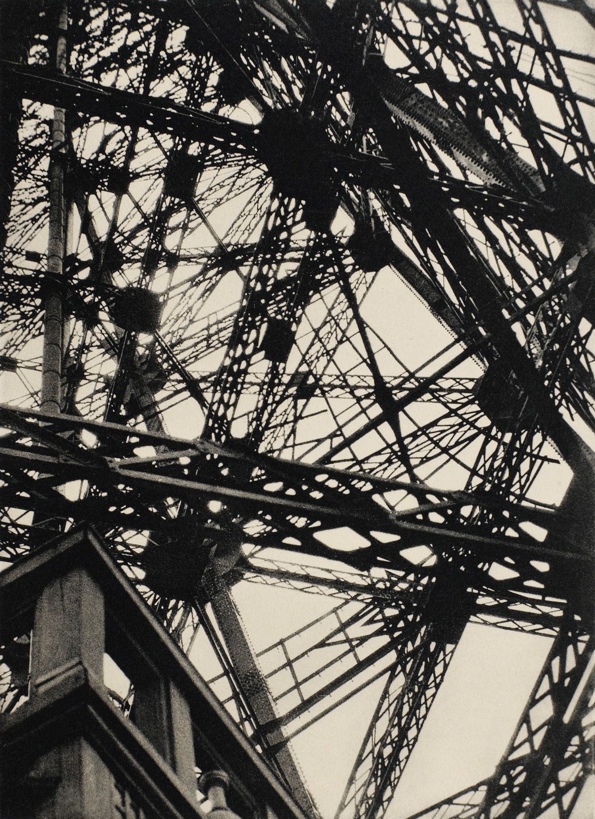 A photograph looking up through the beams of the Eiffel Tower